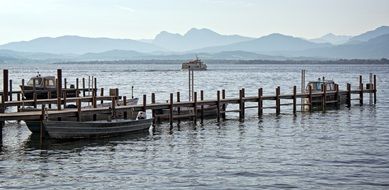 boats near a wooden pier on lake chiemsee