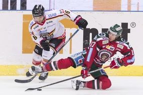 hockey players fight for the puck
