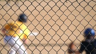 Baseball game behind the fence in summer