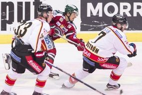 three male ice hockey players in game