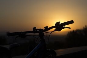 photo bicycle steering wheel on the background of the evening sky