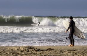 surfer with a board on the beach during the surf