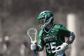 athlete in green uniform with the number "25" in lacrosse