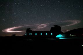 military helicopter under a bright starry sky