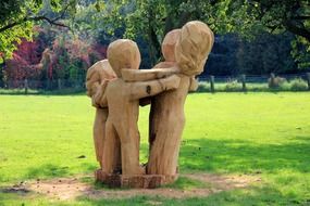 wood sculptures of hugging children