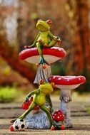 Ceramic figurine of frogs on red mushrooms