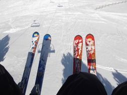 skis of skiers on a lift on a snowy hill