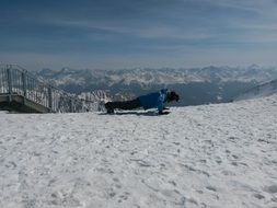 Skiers doing Pushups on snow in mountain landscape