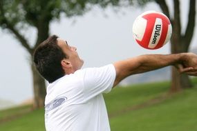 Man is playing volleyball in nature