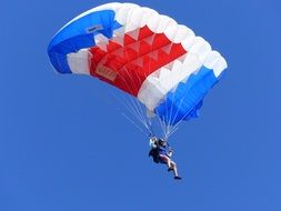 white blue red parachute in the sky
