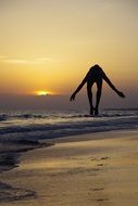 acrobat on the coast at sunset