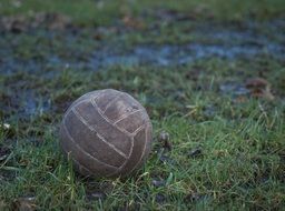 worn ball on green grass