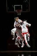 three male Professional Basketball Players in jump together