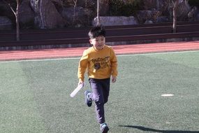 Child is running on the grass