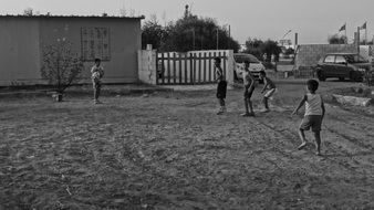 black and white photo of children's football in the village