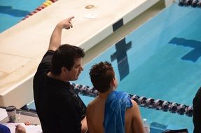 coach and swimmer near the pool