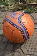 Orange soccer ball lies on the ground