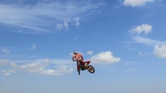 motorcyclist jump under the blue sky