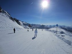 panoramic view of skiers on the track under the bright sun