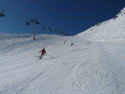 panoramic view of the descent of skiers on the track under the bright sun