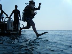 scuba diving from a boat to the sea