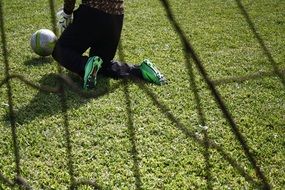 soccer player kneeling with ball