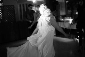 black and white photo of a woman in a white dress at a party