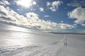 Ski trails on glistening snow at sunny day