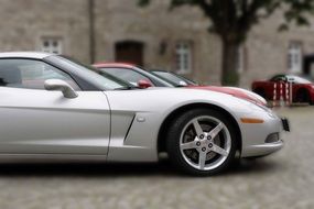 sports cars of different colors are parked near the building