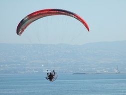 Hand Glider flying over the water