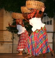 African dancers hold baskets on their heads in the Caribbean