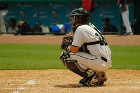catcher sitting on the field in baseball