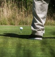 A man stands near the ball in golf