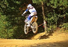 motorcycle racer jumping on a dusty track