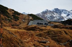 two houses on the slope of a brown mountain in Austria