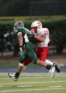 American football players running across the field