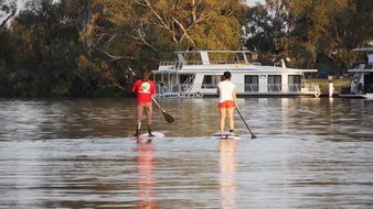couple on the water boards on the river