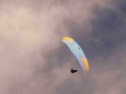 man on a parachute under the clouds