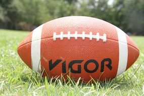 ball for american football on green grass close-up