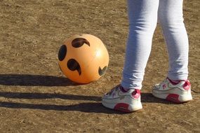 child stands near an inflatable ball
