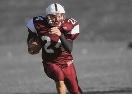 ball carrier in red uniform in american football