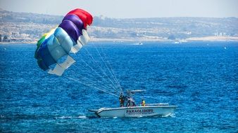 people with Paragliding wing in boat on sea