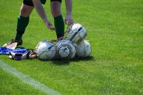 soccer balls in the net on a green field