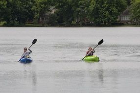 two people are kayaking in a lake