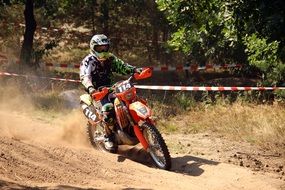 Motorcycle racer in dust on a race track