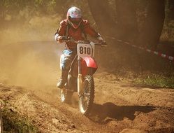 motorcycle racer in a dusty haze on the track