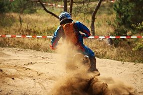 turn of a motorcycle racer in a dusty haze on the track