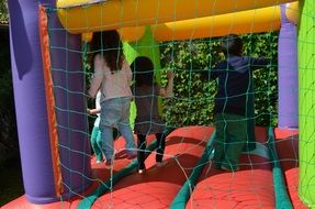 Children play on an inflatable slide