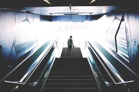 man on top of an escalator in subway