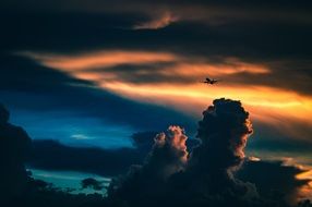 Airplane is on a Sunset Cloudy sky